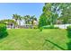 Spacious backyard featuring lush green grass, a screened-in patio, and mature landscaping at 11035 Huron Rd, St Petersburg, FL 33708
