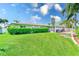 Sprawling backyard with manicured lawn, mature landscaping, and a covered patio perfect for outdoor gatherings at 11035 Huron Rd, St Petersburg, FL 33708