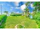 Expansive backyard with lush green grass, mature landscaping, a storage shed, and waterfront access at 11035 Huron Rd, St Petersburg, FL 33708