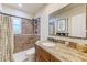 Bathroom with a tiled shower and a vanity with a granite countertop and decorative mirror at 11035 Huron Rd, St Petersburg, FL 33708