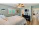 Light-filled bedroom featuring a ceiling fan, a TV, nautical decor and an en suite bathroom at 11035 Huron Rd, St Petersburg, FL 33708