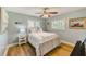Cozy bedroom featuring a ceiling fan, a decorative anchor pillow, and light-filled windows with wood floors at 11035 Huron Rd, St Petersburg, FL 33708
