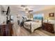 Bedroom featuring wood floors, decorative mirror, ceiling fan, and a TV at 11035 Huron Rd, St Petersburg, FL 33708