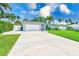 Charming single-story home featuring a well-manicured lawn and a long driveway leading to an attached garage at 11035 Huron Rd, St Petersburg, FL 33708