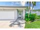 Close-up of the front entrance featuring a brick facade, manicured landscaping and freshly painted door at 11035 Huron Rd, St Petersburg, FL 33708
