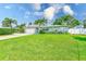 Landscaped front yard with a lush green lawn and mature palm trees framing this single-story home at 11035 Huron Rd, St Petersburg, FL 33708