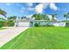 Beautiful single-Gathering home with a lush green lawn and mature landscaping in a sunny setting at 11035 Huron Rd, St Petersburg, FL 33708