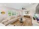 Bright living room with wood floors, comfortable seating, recessed lighting, and large shuttered windows at 11035 Huron Rd, St Petersburg, FL 33708