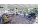 Covered patio featuring brick pavers, ceiling fans, and outdoor seating with green landscaping at 11035 Huron Rd, St Petersburg, FL 33708