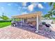 Entertaining screened-in patio with barbecue grill, dining table, comfortable seating, and a brick paved floor at 11035 Huron Rd, St Petersburg, FL 33708