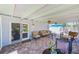 Covered patio featuring brick pavers, ceiling fans, comfortable seating and sliding glass door access at 11035 Huron Rd, St Petersburg, FL 33708
