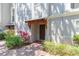 Charming condo entrance with a wooden door, brick walkway, and lush landscaping at 111 S Delaware Ave # 1, Tampa, FL 33606