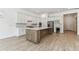 Modern kitchen boasts white cabinetry, stainless steel appliances, and a central island at 11432 Shoreline Trl, Parrish, FL 34219