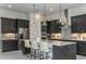 Elegant kitchen with dark cabinetry, stainless appliances, a center island, and modern pendant lights at 11432 Shoreline Trl, Parrish, FL 34219