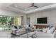 Comfortable living room with a large sectional sofa, stylish decor, and access to the outdoor patio at 11432 Shoreline Trl, Parrish, FL 34219