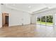 Spacious living room with wood-look tile flooring and sliding glass doors at 11432 Shoreline Trl, Parrish, FL 34219