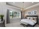 Serene bedroom with a large window, elegant chandelier, and plush furnishings at 11432 Shoreline Trl, Parrish, FL 34219