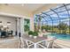 Enclosed patio featuring a dining set, view of the pool and golf course at 11432 Shoreline Trl, Parrish, FL 34219