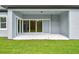 A covered patio with sliding glass doors opening to a grassy area at 11432 Shoreline Trl, Parrish, FL 34219
