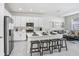 Open-concept kitchen with white cabinetry, stainless steel appliances, and a spacious island with stool seating at 11723 Blackbrook Ct, Seffner, FL 33584