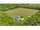 Aerial shot of a home with a pool, outbuildings, and wooded areas at 12345 Citrus Way, Brooksville, FL 34601