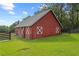 A red barn with white trim sits on a green lawn under a bright blue sky at 12345 Citrus Way, Brooksville, FL 34601