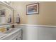 Half bath with a sink, framed art and wainscotting at 12345 Citrus Way, Brooksville, FL 34601