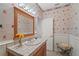 Well-lit bathroom featuring beach-themed wallpaper, decorative lighting, a vanity with a tile countertop, and a bench at 12345 Citrus Way, Brooksville, FL 34601