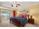 Comfortable bedroom featuring a ceiling fan, a bed with blue bedding, and access to the lanai at 12345 Citrus Way, Brooksville, FL 34601