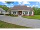 Charming single-story home featuring a brick and white exterior, covered porch with swings, and a brick-paved driveway at 12345 Citrus Way, Brooksville, FL 34601