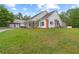 Well-maintained home and detached garage with brick and white exteriors on a spacious, verdant lawn at 12345 Citrus Way, Brooksville, FL 34601