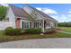 Beautifully landscaped home with a manicured lawn, brick accents, and a covered porch with lovely garden views at 12345 Citrus Way, Brooksville, FL 34601