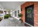 Cozy front porch with rocking chairs, brick accents, and a beautifully decorated front door at 12345 Citrus Way, Brooksville, FL 34601