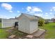 A white shed with a metal roof is surrounded by grass and foliage at 12345 Citrus Way, Brooksville, FL 34601