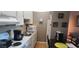 Compact kitchen featuring white cabinetry, appliances, and an adjacent dining area at 1235 S Highland Ave # 5-402, Clearwater, FL 33756