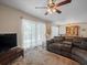 Bright living room with a ceiling fan, sliding glass doors, comfortable seating, and dining area at 1303 N Mcmullen Booth Rd # 1303, Clearwater, FL 33759