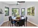 Bright dining room with modern light fixture and three windows overlooking the landscaped backyard at 1310 Country Trails Dr, Safety Harbor, FL 34695