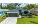 Charming home with a gray roof, manicured lawn, and beautiful landscaping at 1310 Country Trails Dr, Safety Harbor, FL 34695