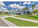 Inviting home with a green lawn, a paved driveway, and neatly trimmed landscaping at 1310 Country Trails Dr, Safety Harbor, FL 34695