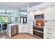 Modern white kitchen boasts stainless steel appliances and a spacious quartz countertop at 1310 Country Trails Dr, Safety Harbor, FL 34695