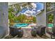 Inviting outdoor patio with comfortable seating overlooking a sparkling pool and lush landscape at 1310 Country Trails Dr, Safety Harbor, FL 34695