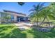 Expansive backyard featuring an in-ground pool, screened lanai, lush lawn, and serene lake views at 1324 Eckles Dr, Tampa, FL 33612