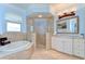 Spacious bathroom featuring a glass shower, tub, and vanity with white cabinets at 1324 Eckles Dr, Tampa, FL 33612