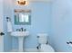 Powder room with pedestal sink, blue walls and beach house decor creates a relaxing, coastal vibe at 1324 Eckles Dr, Tampa, FL 33612