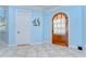 Bright foyer with an arched wood door, tiled flooring, and neutral-toned walls at 1324 Eckles Dr, Tampa, FL 33612