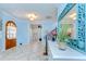 Bright foyer with light blue walls, tile floors, and an arched wood door at 1324 Eckles Dr, Tampa, FL 33612