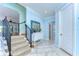 Entryway with a staircase, neutral tile floors, and a coastal-themed blue mirror at 1324 Eckles Dr, Tampa, FL 33612