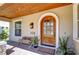 Charming front porch features wood ceiling, arched wood door and tiled brick flooring at 1324 Eckles Dr, Tampa, FL 33612