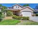 Beautiful home features a manicured lawn, arched front door, and an attached two-car garage at 1324 Eckles Dr, Tampa, FL 33612