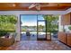 Screened lanai with brick flooring, ceiling fan, outdoor kitchen, and views of the pool and lake at 1324 Eckles Dr, Tampa, FL 33612
